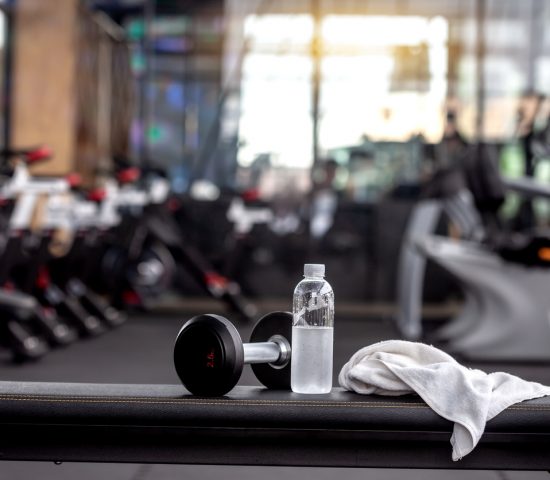 Dumbbell, water bottle, towel on the bench in the gym. Dumbbell, water bottle, towel on the bench in the gym.